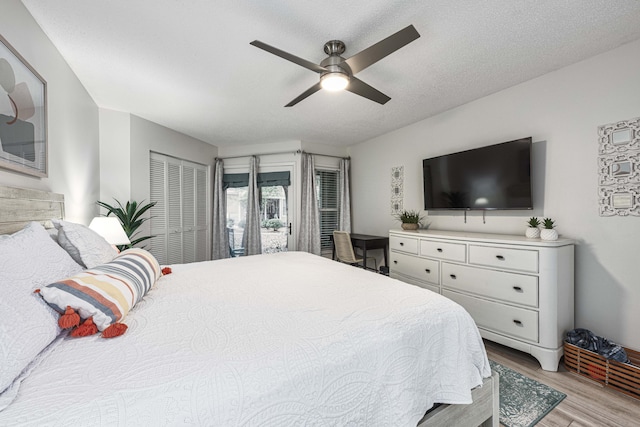 bedroom featuring light wood-type flooring, ceiling fan, a textured ceiling, and a closet