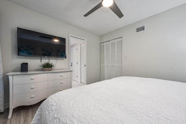 bedroom featuring ceiling fan, a textured ceiling, and light wood-type flooring