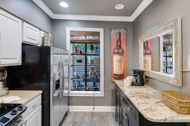 kitchen featuring crown molding, white cabinets, light stone counters, stainless steel range, and light hardwood / wood-style floors