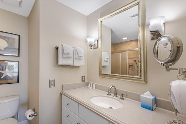 bathroom with toilet, vanity, and walk in shower