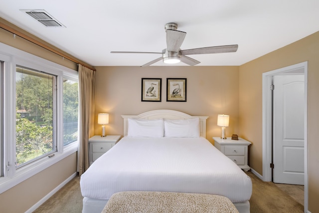 carpeted bedroom with ceiling fan and multiple windows