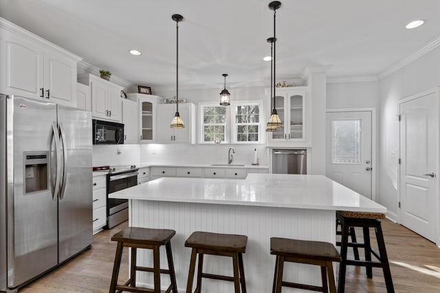 kitchen with tasteful backsplash, white cabinetry, sink, a center island, and stainless steel appliances