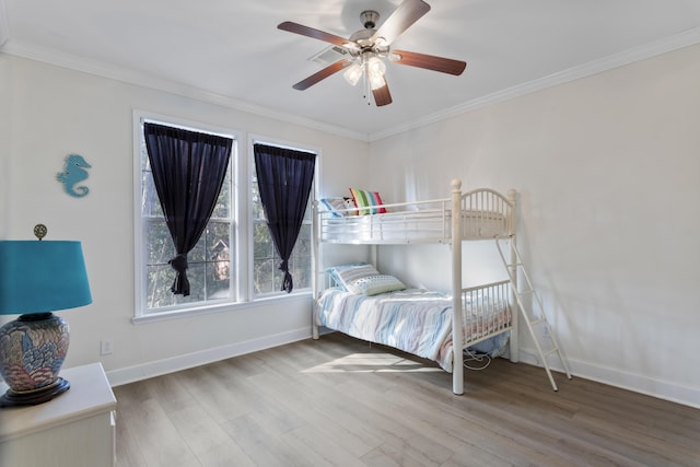 bedroom with hardwood / wood-style flooring, crown molding, and ceiling fan