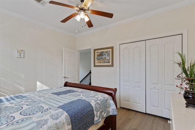 bedroom featuring crown molding, ceiling fan, a closet, and light wood-type flooring