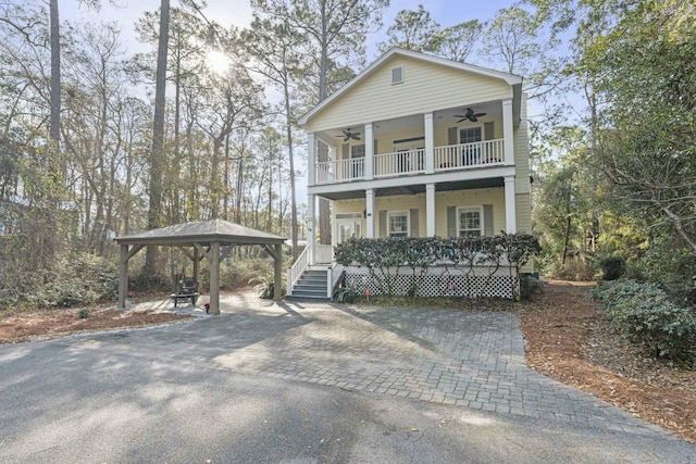 neoclassical home featuring a gazebo, ceiling fan, a porch, and a balcony