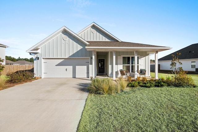 modern farmhouse featuring a garage, a front yard, and a porch