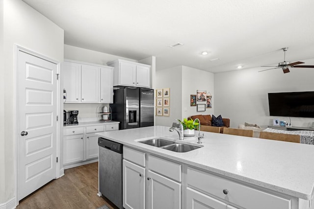 kitchen featuring white cabinets, appliances with stainless steel finishes, dark hardwood / wood-style flooring, sink, and a center island with sink