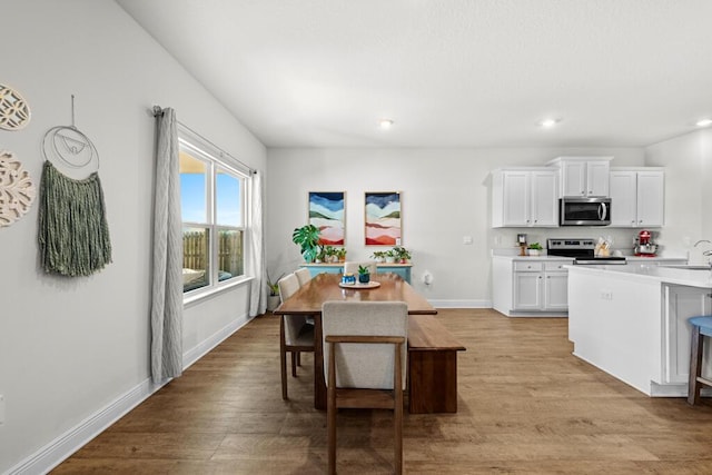 kitchen featuring white cabinets, light hardwood / wood-style floors, appliances with stainless steel finishes, and sink