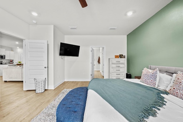 bedroom featuring light wood-type flooring, ceiling fan, and ensuite bath