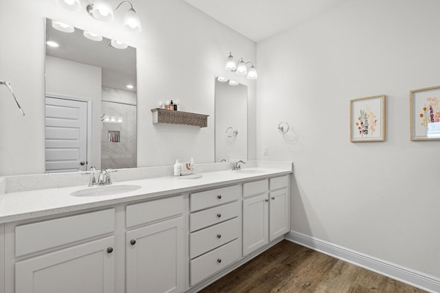 bathroom with hardwood / wood-style flooring, a shower, and vanity