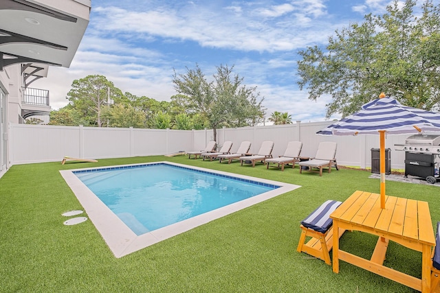 view of pool with a yard and grilling area