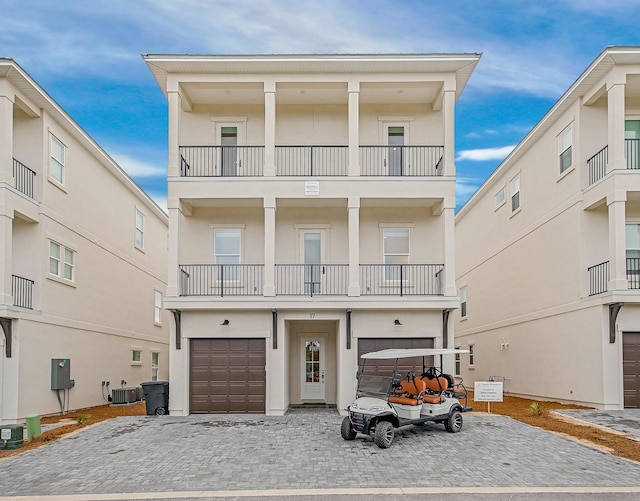 view of front of house with a balcony, a garage, and central air condition unit