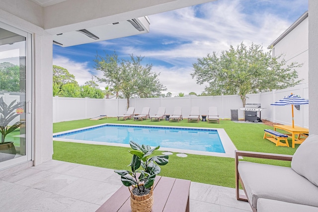 view of pool with a patio, a yard, and area for grilling