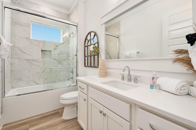 full bathroom with enclosed tub / shower combo, toilet, and vanity