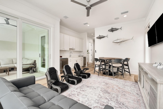 living room with light hardwood / wood-style floors, sink, and ceiling fan