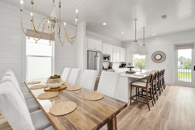 dining room featuring wooden ceiling, wooden walls, an inviting chandelier, and light wood-type flooring