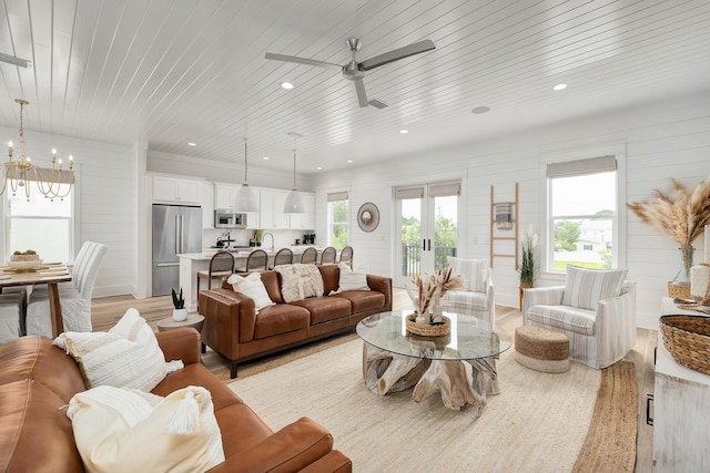 living room with wood ceiling, wooden walls, and light hardwood / wood-style floors