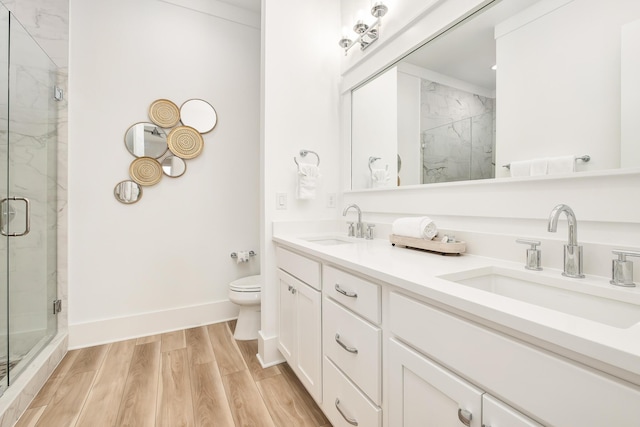 bathroom featuring hardwood / wood-style floors, an enclosed shower, vanity, and toilet