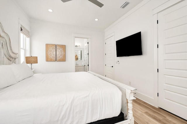 bedroom featuring ceiling fan, light hardwood / wood-style floors, ensuite bathroom, and ornamental molding