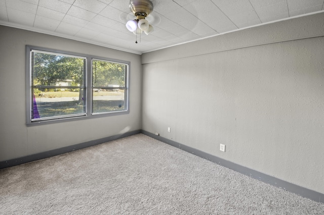 carpeted empty room with ceiling fan, a textured wall, and baseboards