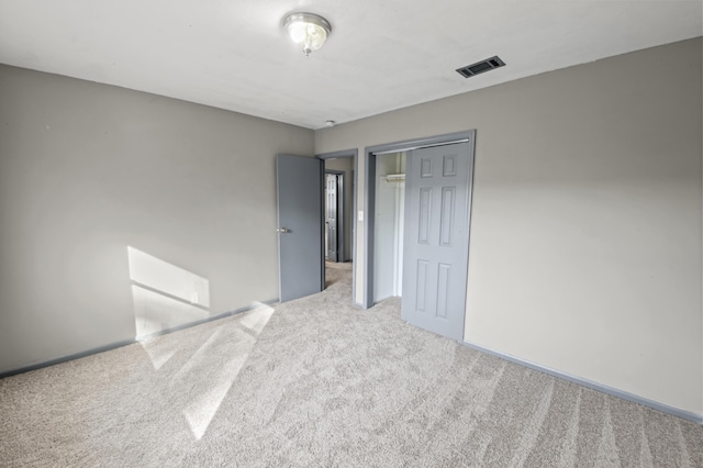 unfurnished bedroom with carpet floors, baseboards, visible vents, and a closet