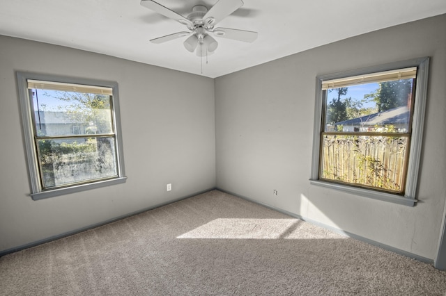 carpeted spare room featuring a ceiling fan