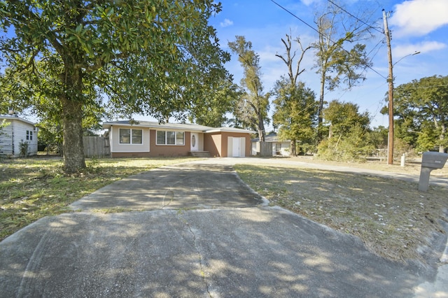 ranch-style home with a front yard, crawl space, fence, a garage, and driveway