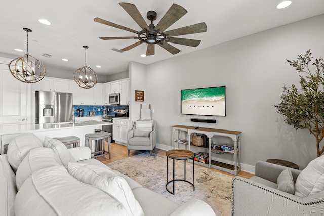 living room featuring ceiling fan and light hardwood / wood-style flooring