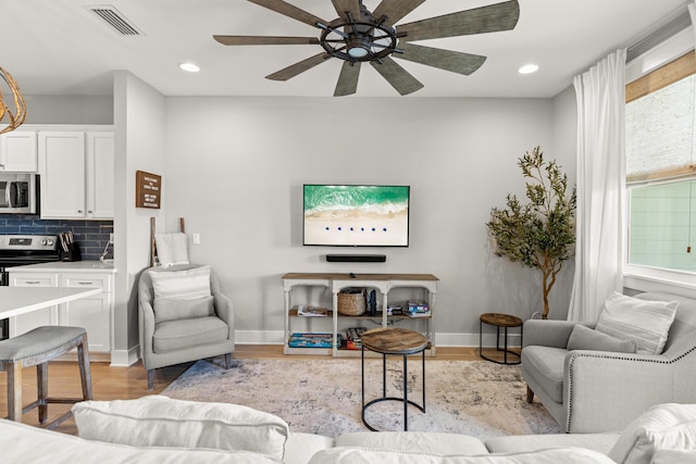 living room featuring ceiling fan and light wood-type flooring