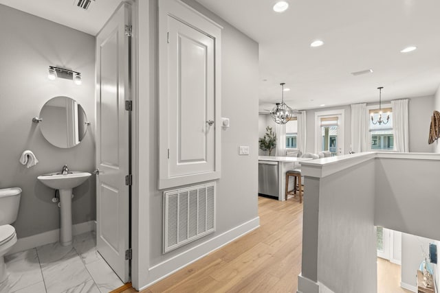 corridor with sink and a chandelier