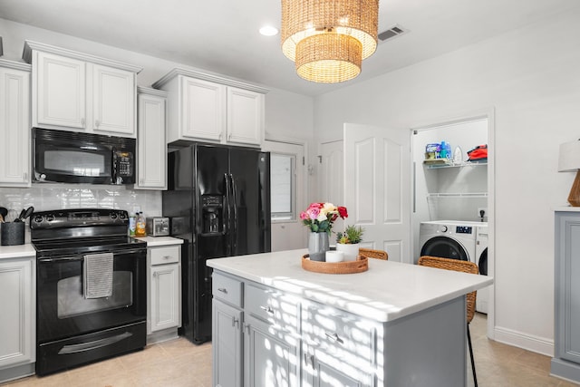 kitchen featuring white cabinetry, a center island, tasteful backsplash, black appliances, and washer / dryer