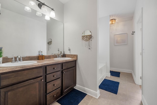 bathroom featuring tile patterned floors, vanity, and a washtub