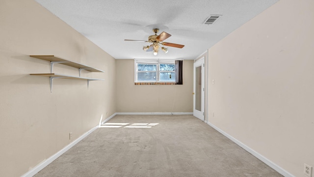 carpeted spare room featuring ceiling fan and a textured ceiling