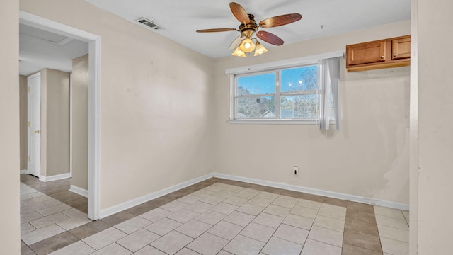 tiled empty room featuring ceiling fan