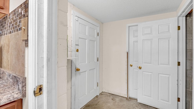 hall featuring a textured ceiling