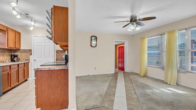 kitchen featuring light tile patterned floors, a textured ceiling, ceiling fan, and decorative backsplash