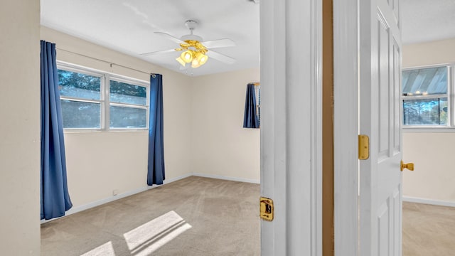 empty room with light colored carpet and ceiling fan