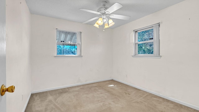 spare room with light carpet, a textured ceiling, and ceiling fan