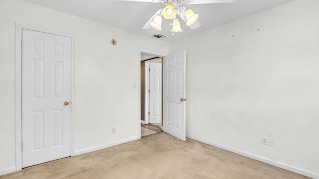 unfurnished bedroom featuring ceiling fan and light colored carpet