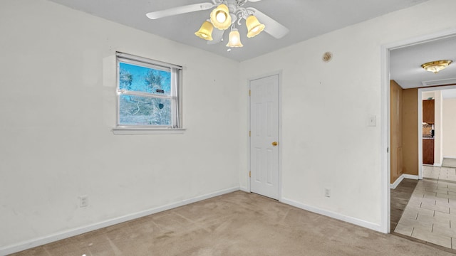 carpeted spare room with ceiling fan