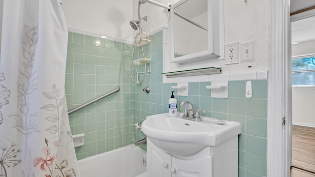 bathroom with vanity, tile walls, and shower / tub combo with curtain