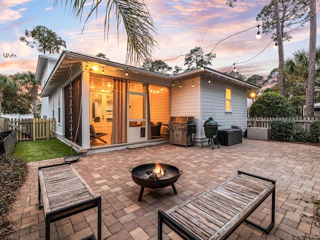 back house at dusk with a patio area and a fire pit