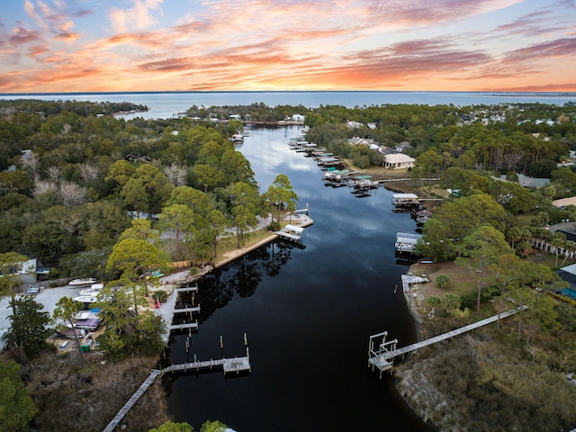 aerial view at dusk featuring a water view