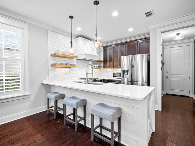 kitchen with custom range hood, hanging light fixtures, dark brown cabinets, kitchen peninsula, and stainless steel appliances