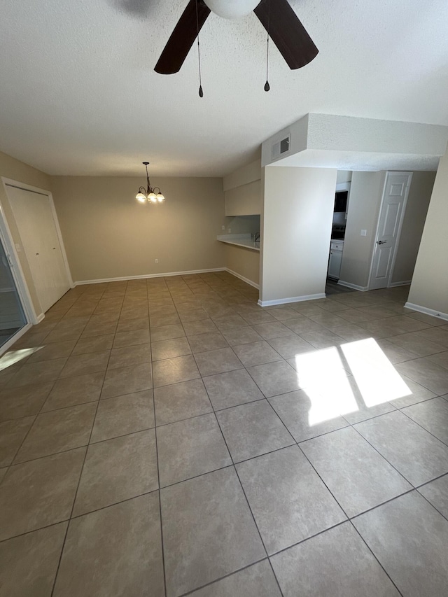 unfurnished living room featuring light tile patterned flooring, ceiling fan with notable chandelier, and a textured ceiling