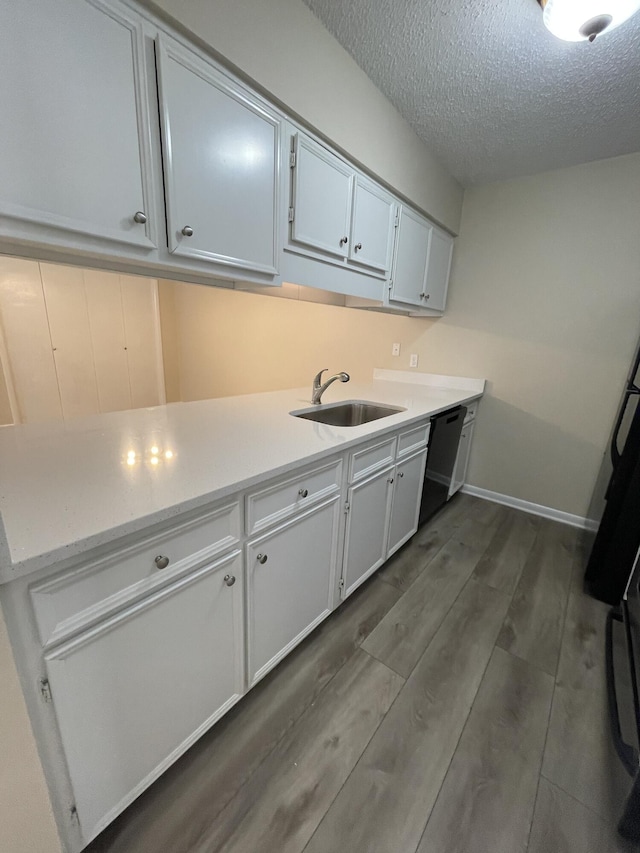 kitchen featuring white cabinetry, black dishwasher, sink, and a textured ceiling