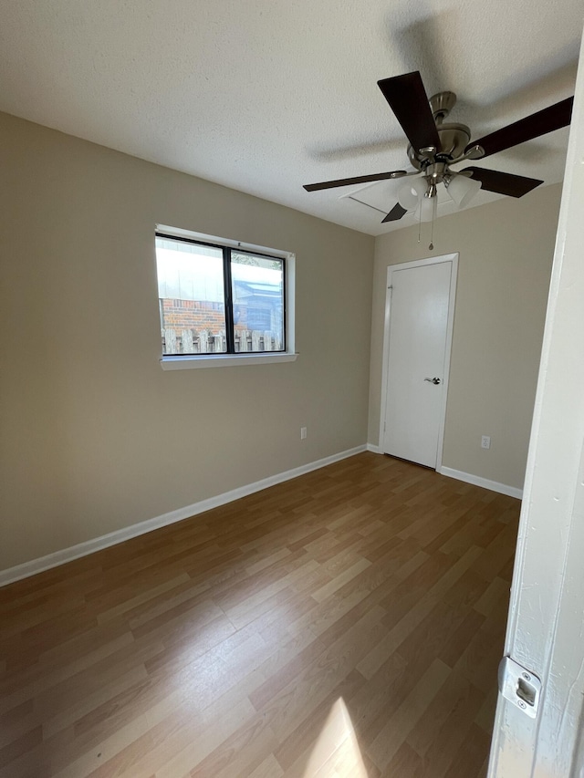 empty room featuring a textured ceiling and light hardwood / wood-style floors