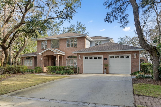 traditional-style house with driveway, a garage, a shingled roof, a front lawn, and brick siding