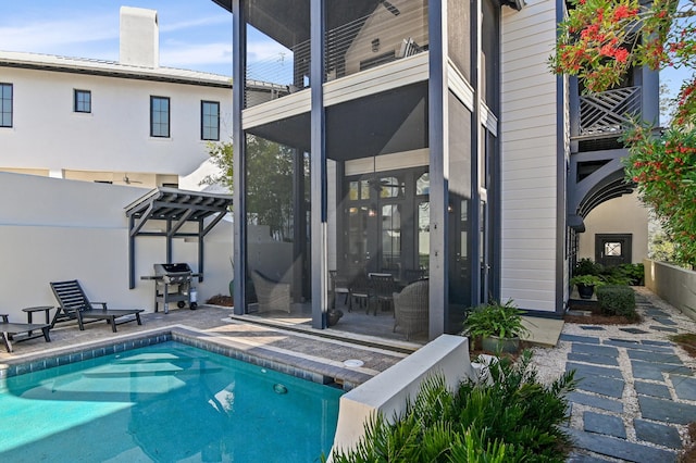 back of house featuring a balcony, a sunroom, and a patio