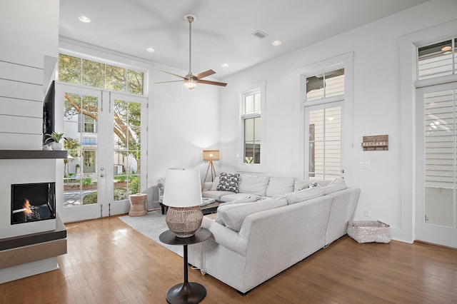 living room featuring french doors, a multi sided fireplace, ceiling fan, and hardwood / wood-style floors